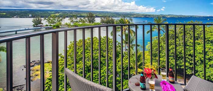 A scenic ocean view from a balcony at Big Island Resorts with a table set for two.